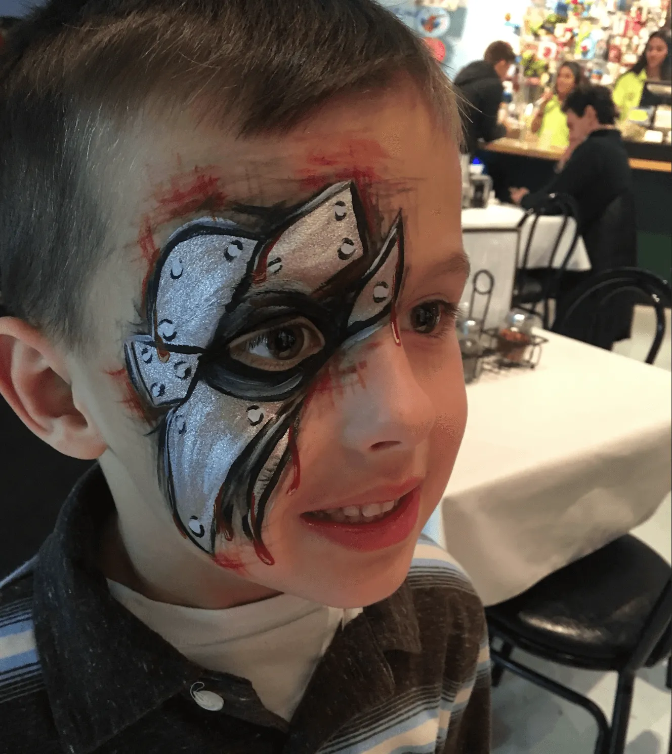 A kid proudly displaying an amazing facepaint artwork