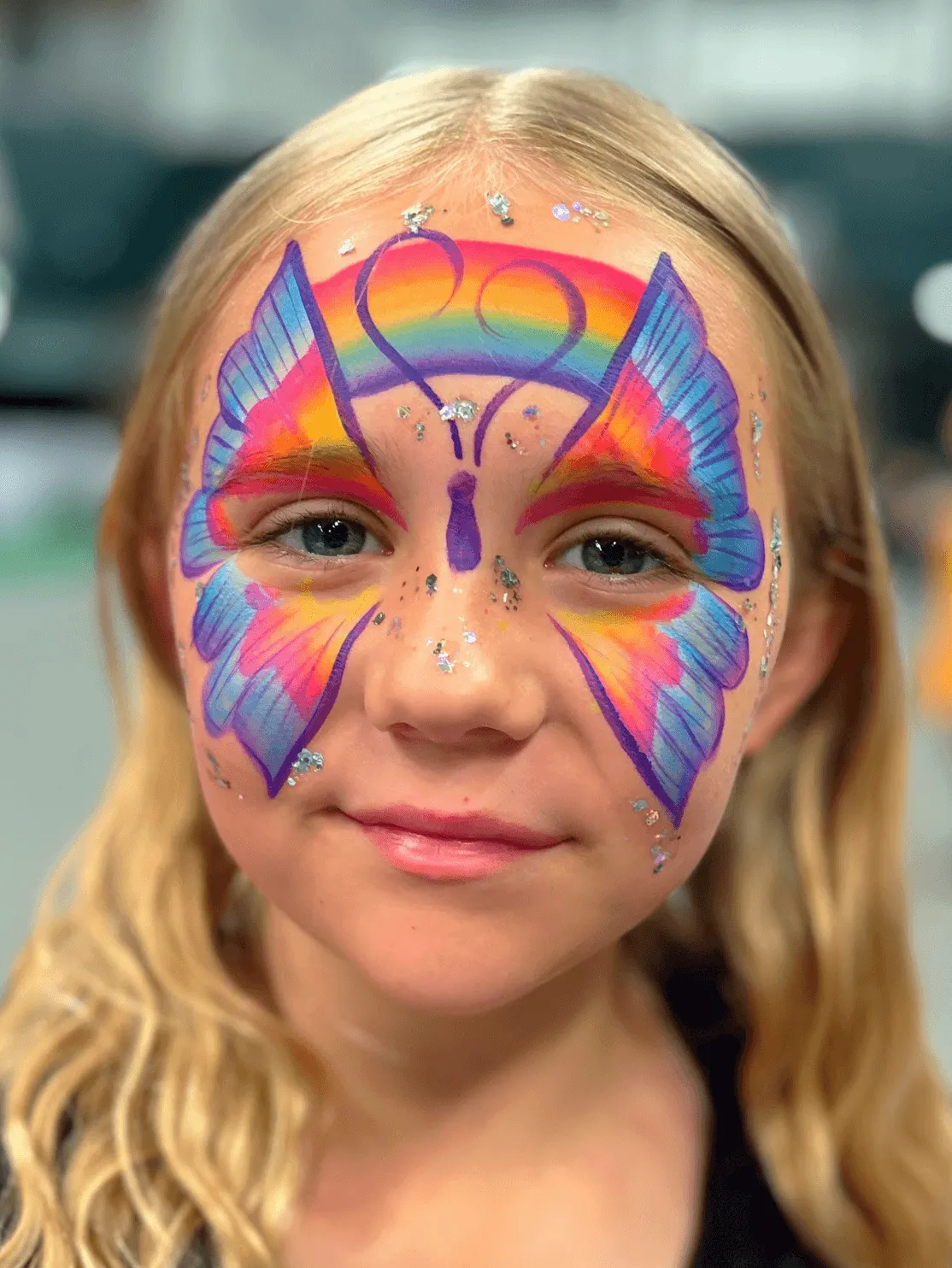 A kid proudly displaying an amazing facepaint artwork