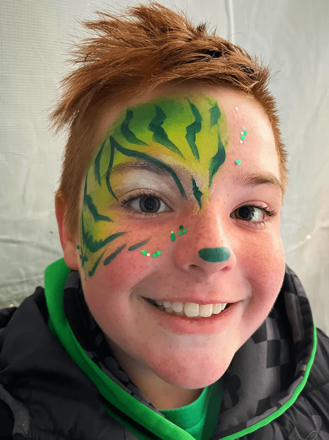 A kid proudly displaying an amazing facepaint artwork