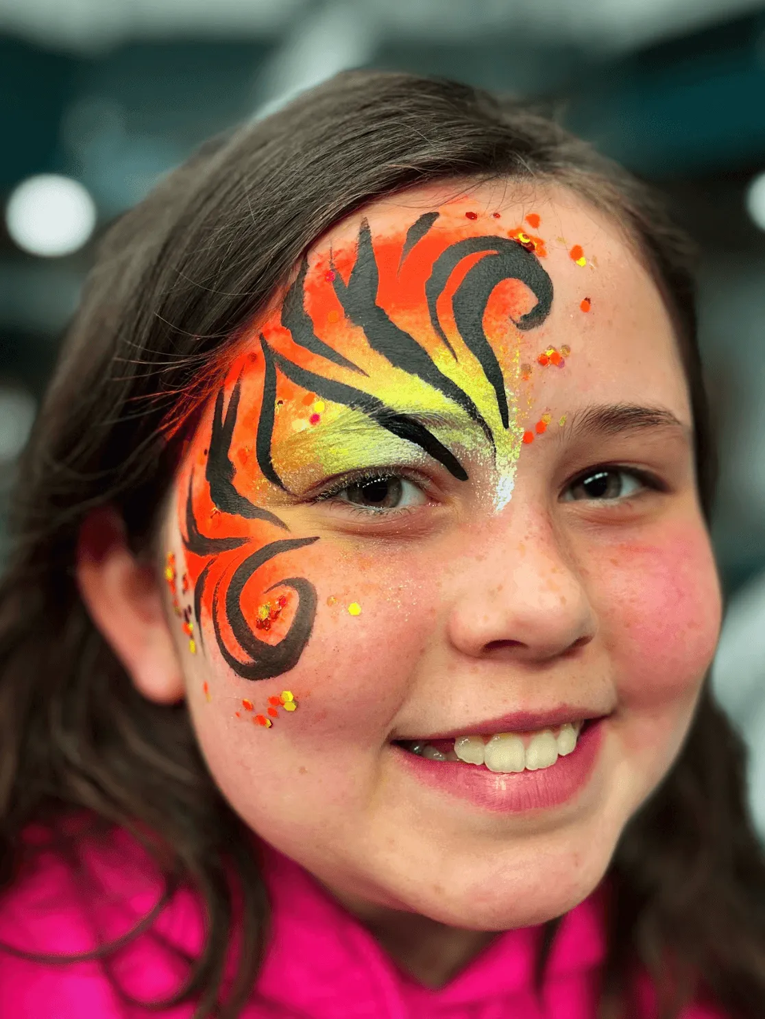 A kid proudly displaying an amazing facepaint artwork