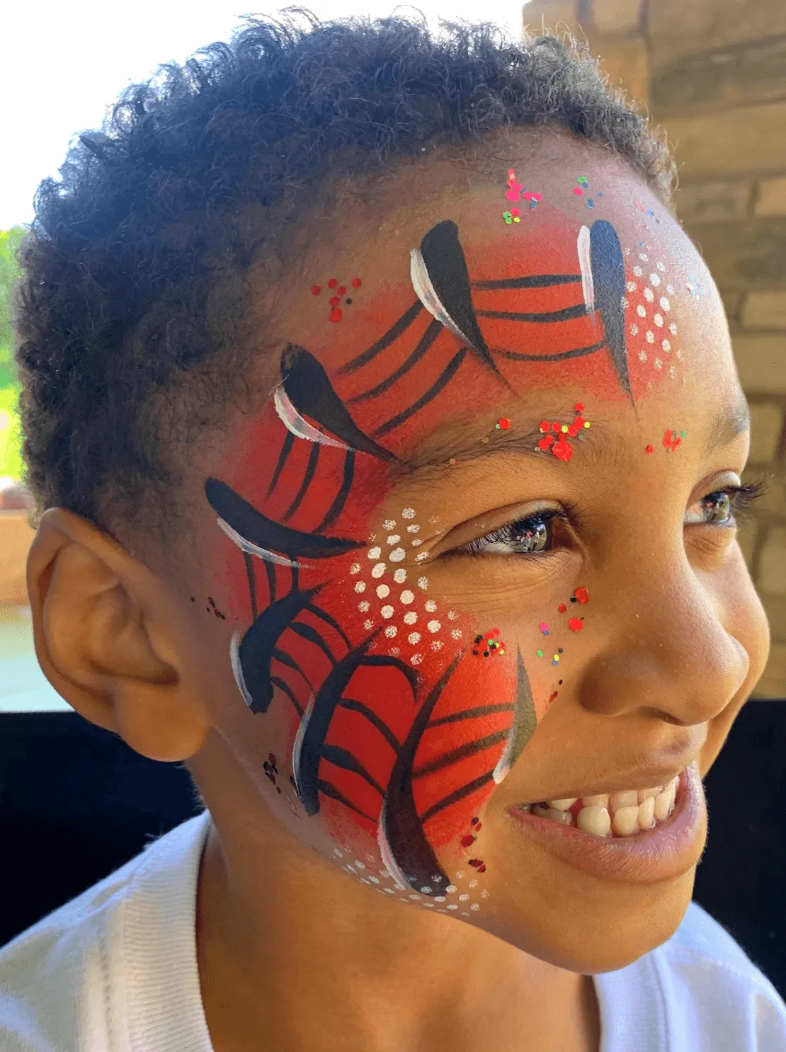 A kid proudly displaying an amazing facepaint artwork