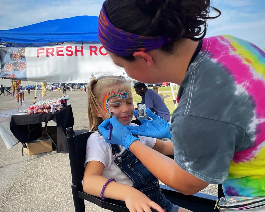 A kid proudly displaying an amazing facepaint artwork