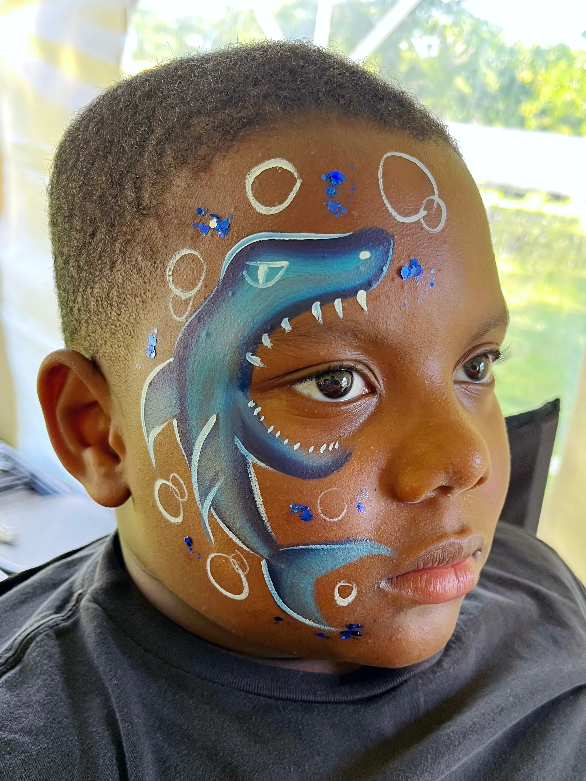 A kid proudly displaying an amazing facepaint artwork