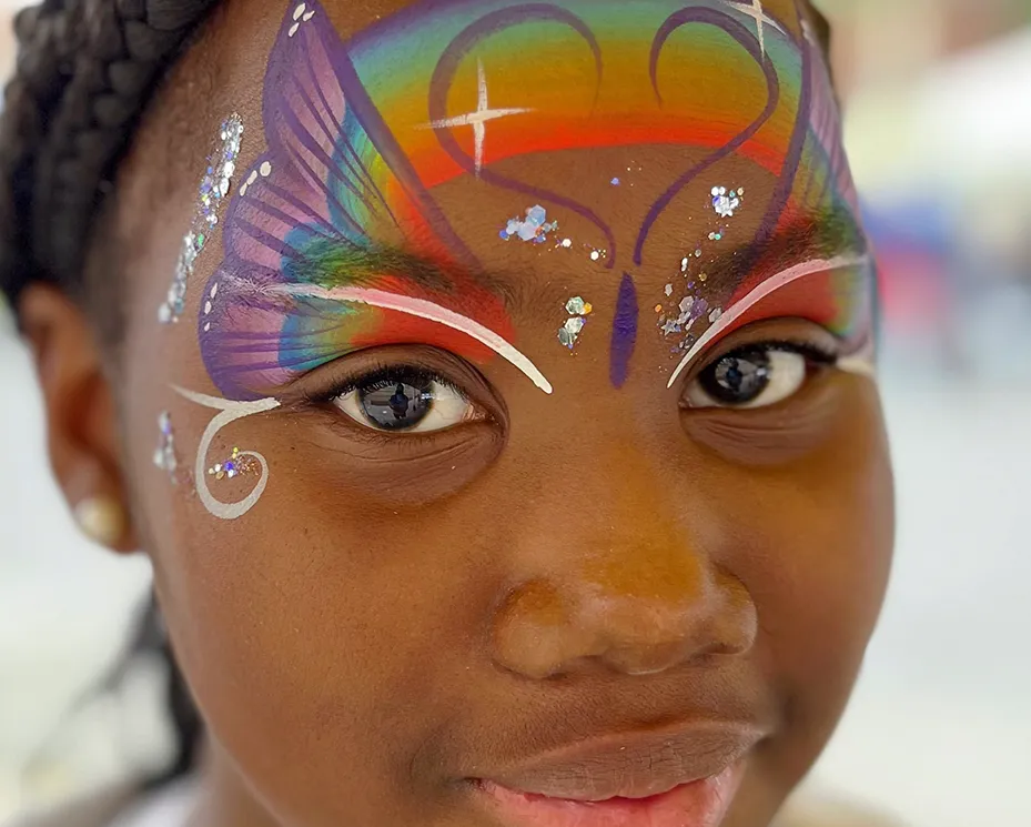 A kid proudly displaying an amazing facepaint artwork